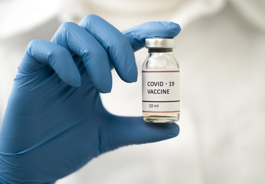 front-view-doctor-holding-coronavirus-vaccine